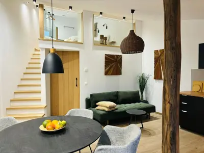 a living room with a table and a green couch at Le Marzelheide 2 in Lontzen
