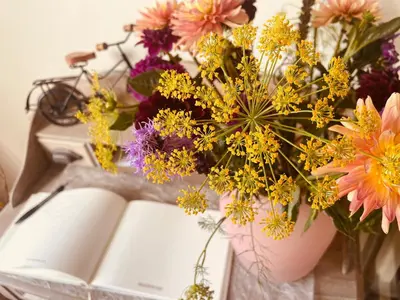 a book and a bouquet of flowers next to a vase at B&B De Zandput in Balen