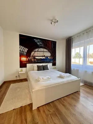 a bedroom with a white bed with a painting on the wall at Vintage Station in Ans