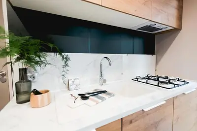 a kitchen counter with a sink and a stove at Camping Papillon Kinrooi - Vakantiehuis Familie 6P in Kinrooi