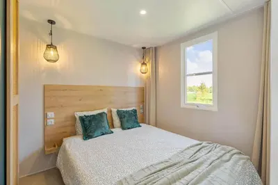 a bedroom with a bed with two pillows and a window at Camping Papillon Kinrooi - La Casetta in Kinrooi