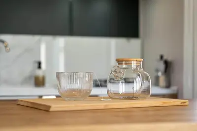 a glass jar and a glass cup on a cutting board at Camping Papillon Kinrooi - La Casetta in Kinrooi