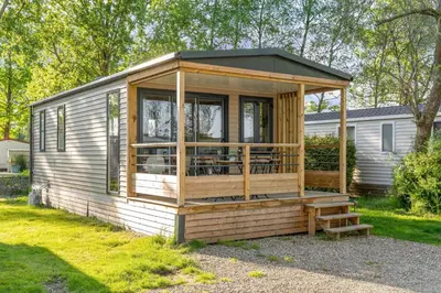a wooden cabin with a porch and a deck at Camping Papillon Kinrooi - Vakantiehuis Premium 4P in Kinrooi
