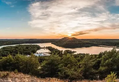 a view of a river with the sunset in the background at Camping Papillon Kinrooi - Pipowagen 2p terras in Kinrooi