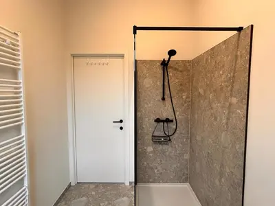 a shower with a glass door in a bathroom at Spacious 3-Floor Holiday Home for 8 Guests in Bree