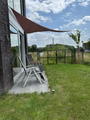 a chair and an umbrella on a porch at Dukes View -explore Haspengouw & surrounding towns in Zoutleeuw