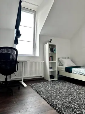 a bedroom with a bed and a desk and a chair at Dukes View -explore Haspengouw & surrounding towns in Zoutleeuw