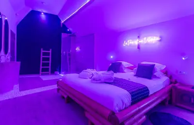 a purple bedroom with a large bed in a room at L'Améthyste in Crisnée