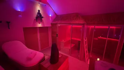 a room with a pink room with a bed and a couch at L'Améthyste in Crisnée