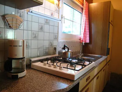a kitchen counter with a stove and a coffee maker at Lanklaar Chalet with Garden in Lanklaar