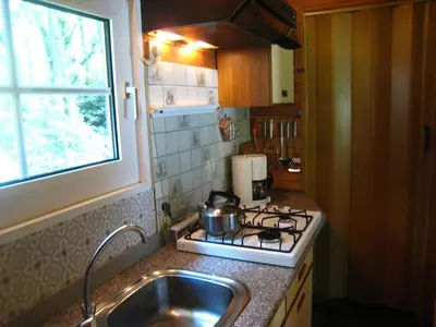 a kitchen with a stove and a sink and a window at Lanklaar Chalet with Garden in Lanklaar