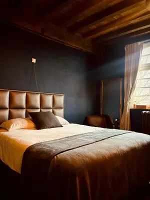 a bedroom with a large bed with yellow sheets and a window at 'T Rood Kasteel in Hasselt