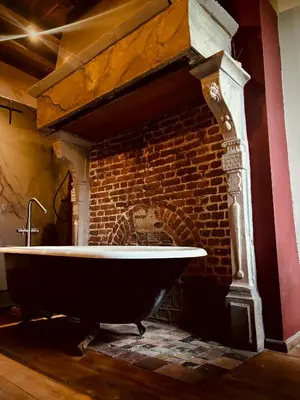 a bath tub in front of a brick fireplace at 'T Rood Kasteel in Hasselt