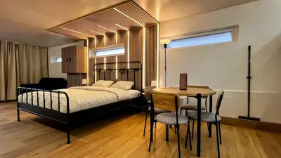 a bedroom with a bed and a table and a tableablish at Chez Margueritte, Cosy, Jacuzzi & Parking Facile in Liège