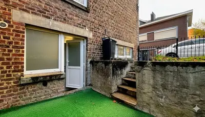 a door to a brick building with a green floor at Chez Margueritte, Cosy, Jacuzzi & Parking Facile in Liège