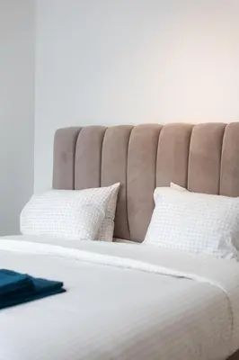 a bed with white sheets and pillows on it at Moni 2G Residence in Seraing