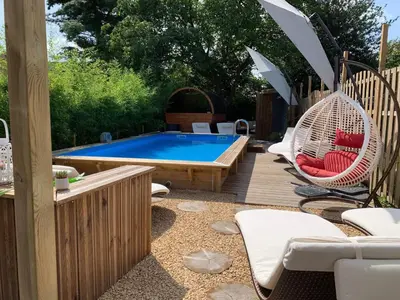 a patio with a pool and chairs and an umbrella at Duplex 7 avec Spa Privé in Herstal