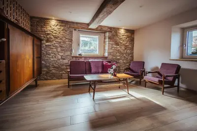 a living room with a table and purple chairs at Im Prummehuck in Raeren