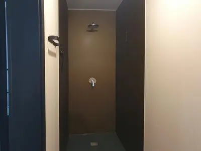 a bathroom with a shower stall with a mirror at Camping Natuurlijk Limburg - Appartement 6p in Voeren
