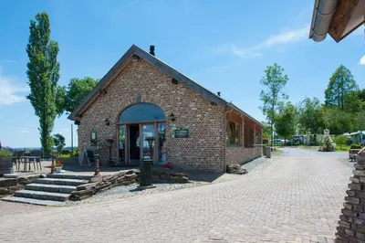 a brick building on a cobblestone street at Camping Natuurlijk Limburg - Appartement 6p in Voeren