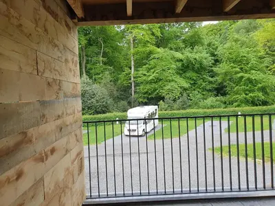 a rv parked in a driveway behind a fence at Camping Natuurlijk Limburg - Appartement 6p in Voeren