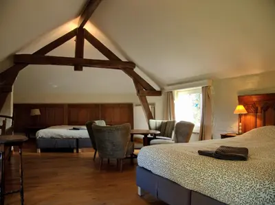 a bedroom with two beds and a table and chairs at Hoefke Voort - Familievakantie midden in de natuur