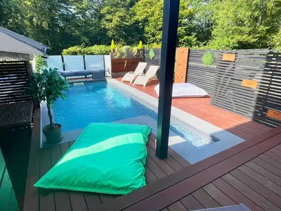 a swimming pool with a green pillow on a deck at Apartment Design Suite in Jehanster
