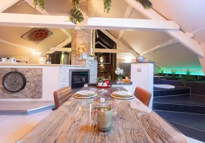a dining room with a table and a fireplace at Apartment Design Suite in Jehanster