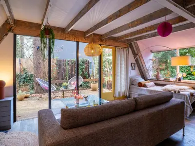 a living room with a couch and a large window at Boshuisje Rekem - Tanuki in Lanaken