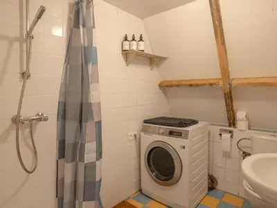 a bathroom with a washing machine and a toilet at Boshuisje Rekem - Tanuki in Lanaken