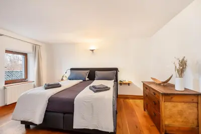 a bedroom with a large bed and a wooden dresser at Zum Alten Kuhstall - Südgarten & Terrasse - Großes Landhaus mit Sauna in Lontzen