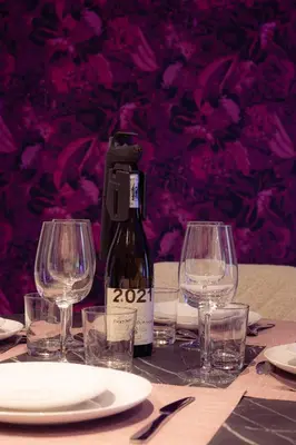 a bottle of wine sitting on a table with glasses at SuiteDreams - Ruby Suite Liège in Liège
