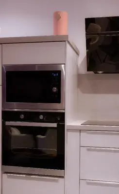 a microwave oven in a kitchen with white cabinets at SuiteDreams - Ruby Suite Liège in Liège