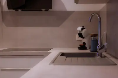 a kitchen counter with a sink and a faucet at SuiteDreams - Ruby Suite Liège in Liège