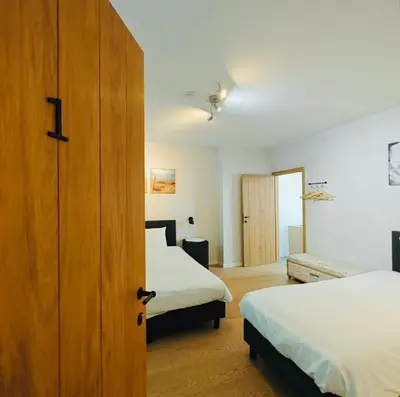 a hotel room with two beds and a door at Logies-Bistro Rosa in Maaseik