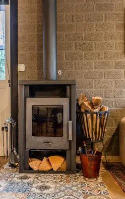 a fireplace in a living room with a brick wall at Lux Bos Chalet in Lanaken