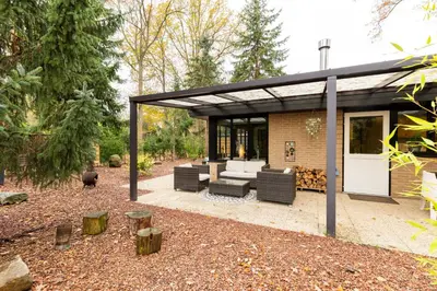 a pavilion with a couch and chairs on a patio at Lux Bos Chalet in Lanaken