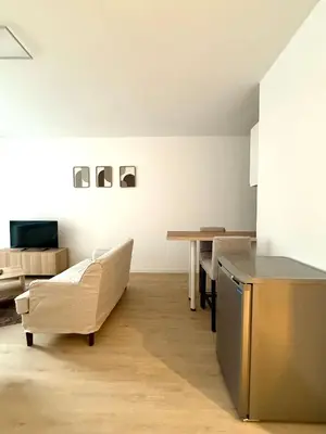 a living room with a couch and a table at Studio moderne au coeur du quartier Saint Adalbert in Liège