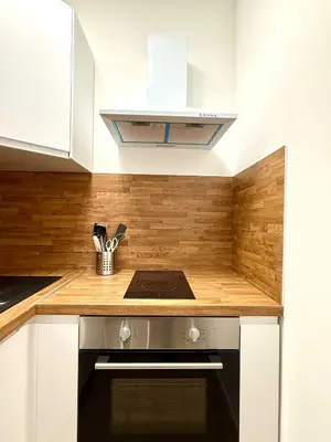 a kitchen with white cabinets and a stove at Cosy studio en plein centre pour 2 personnes in Liège