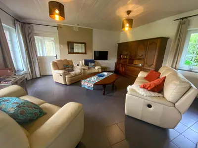 a living room with two couches and a table at Holiday Home Heidebos für 8 Personen by Interhome in Oudsbergen