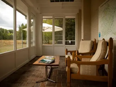 a porch with chairs and a table and windows at Holiday Home Heidebos für 8 Personen by Interhome in Oudsbergen