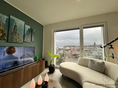 a living room with a couch and a large window at La parenthèse céleste - 2 chambres & Sauna in Liège