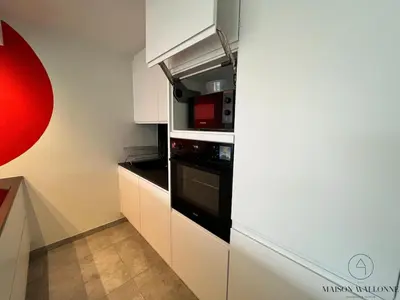 a kitchen with a black oven and a microwave at La parenthèse céleste - 2 chambres & Sauna in Liège