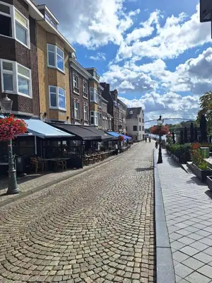 a cobblestone street in a town with tables and buildings at Villa Bonifica in Riemst