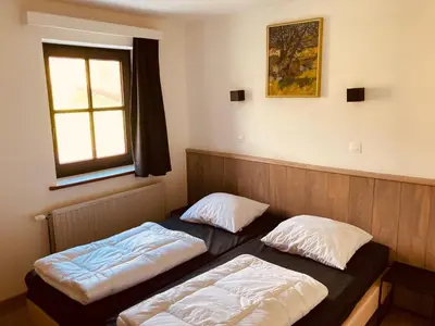 two beds sitting in a room with a window at De Molenhoeve Gezinswoning in Voeren