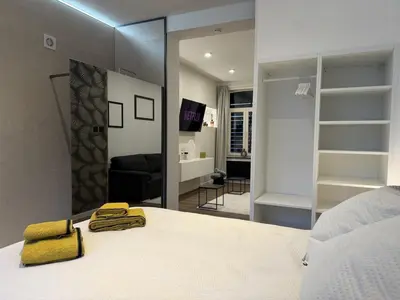 a bedroom with a white bed and a mirror at Suite Luxueuse avec jaccuzi sans vis-à-vis in Liège