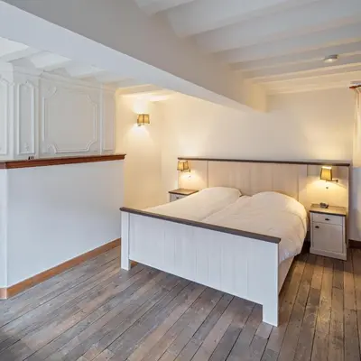 a bedroom with a large bed and two night stands at Vakantiewoning Begijnhof 54 in Sint-Truiden