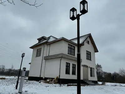 a large white house in the snow with a light pole at Hidden Secret of Nature in Neeroeteren