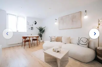 a white living room with a couch and a table at Chic et cosy idéal pour un séjour à Liège in Liège