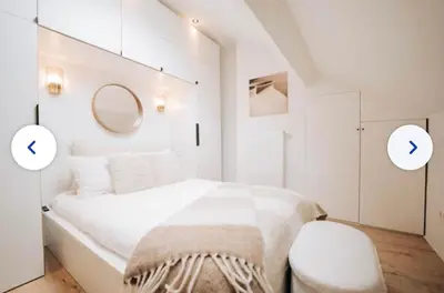 a white bedroom with a bed and a mirror at Chic et cosy idéal pour un séjour à Liège in Liège